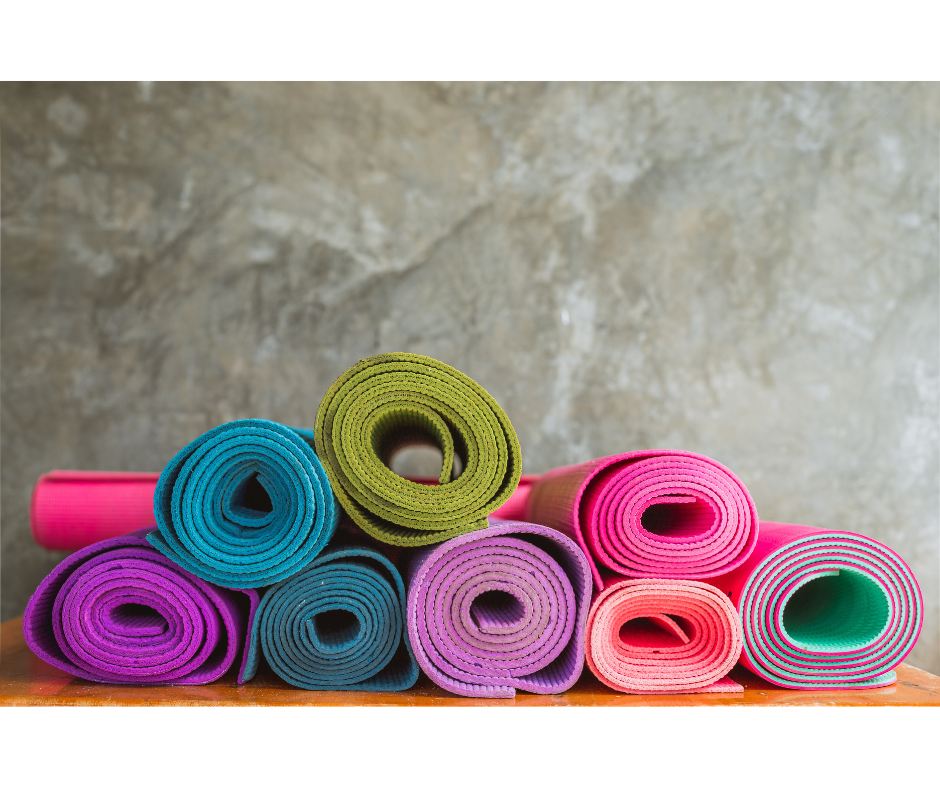 colorful rolled yoga mats against a mottled gray background