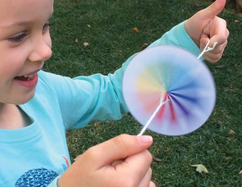 girl spinning rainbow spinner