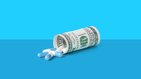 dollar rolled as if it's a bill bottle, with a few pills spilling from it