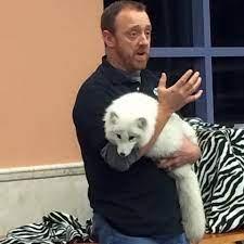 man holding arctic fox