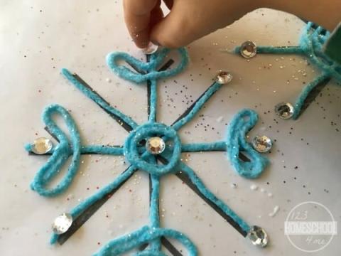 snowflake made of blue yarn with some beads on it
