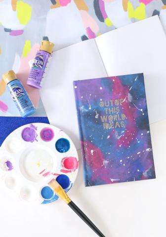 paint palette and notebook painted like a galaxy