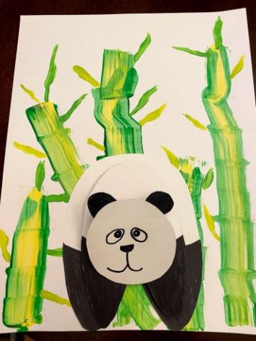 construction paper panda on a paper painted to look like bamboo