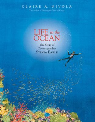 Woman in scuba gear in a dark blue ocean with a school of fish following her and some coral on the bottom left of the cover