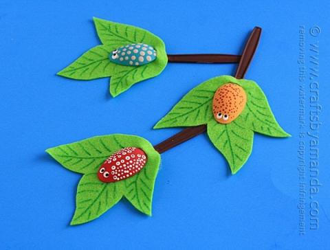 plastic spoons decorated to look like bugs and branches with felt leaves