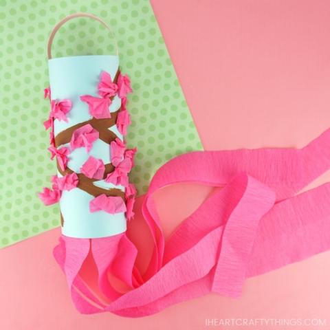 windsock made of toilet paper tube and decorated to look like a cherry blossom branch