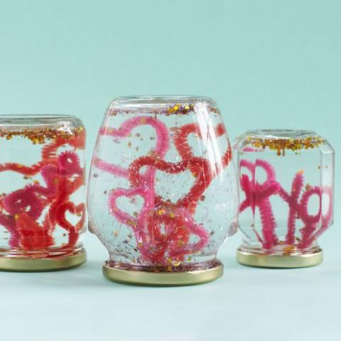 snowglobes made of glass jars with heart shaped pipecleaners inside