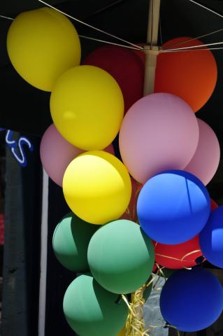 A yellow, red, pink, blue and green bunch of balloons.