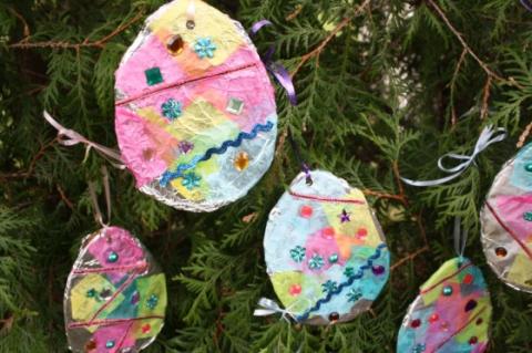 egg shapes of tin foil decorated with tissue paper, beads, and ribbon