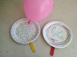 balloon and two paper plate paddles