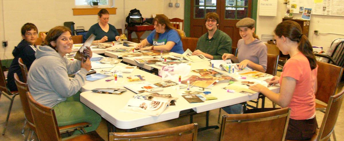Teens preparing craft around a large table.