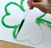 shamrock made of salt and glue being painted with green watercolors