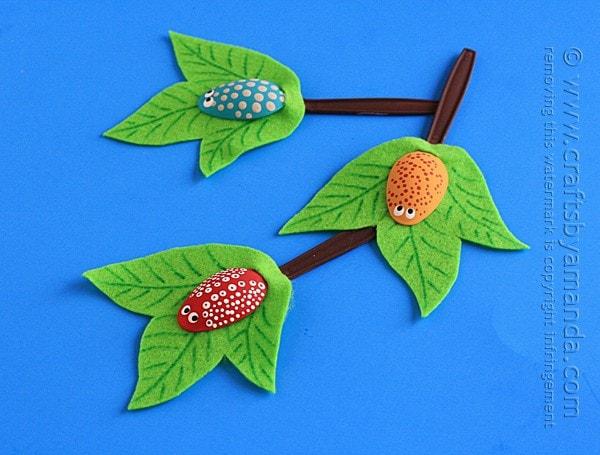plastic spoons decorated to look like bugs and branches with felt leaves