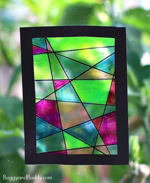 stained glass art made with sharpies and a black frame hung in a window