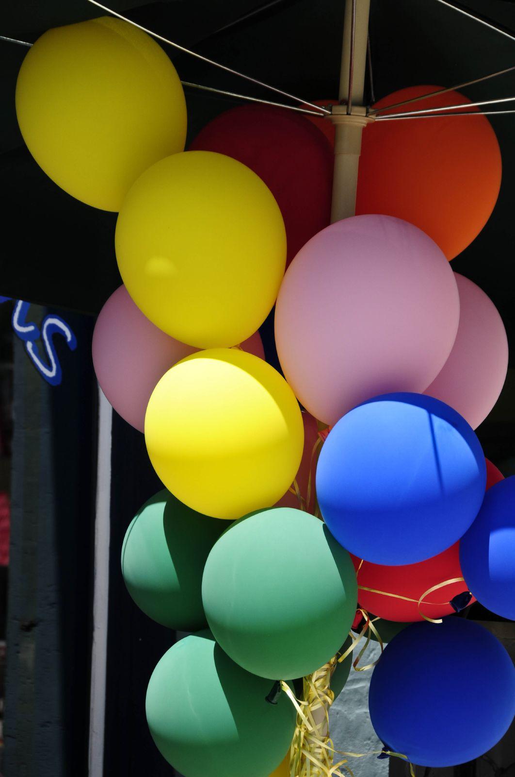 A yellow, red, pink, blue and green bunch of balloons.