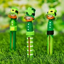 dolly pegs painted green and decorated as leprechauns standing in the grass